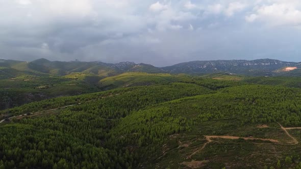 Drone Shot (rotating) of Hilly Arid Landscape covered with Dark Clouds