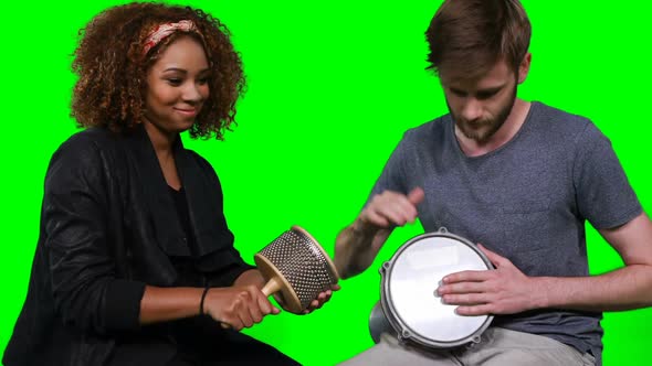 Happy musicians playing cabasa and drum