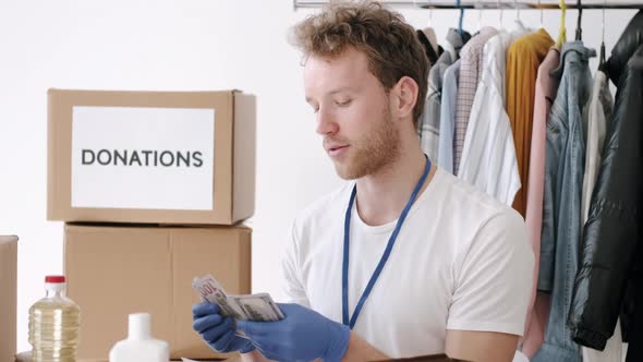 Young Volunteer Checking Clothes Donation Box and Making Notes Humanitarian Aid