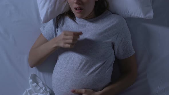 Pregnant Lady Holding Tummy and Sleeping on Back in Bed, Uncomfortable Position