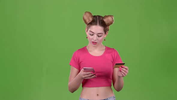 Teenager with a Credit Card and a Phone in His Hands. Green Screen. Slow Motion