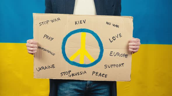 Boy Holds Cardboard with Peace Symbol for for the War in Ukraine