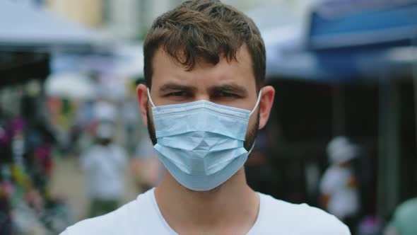 Man in Covid19 Epidemic Face Mask Looking at Camera Stands on Asian Market