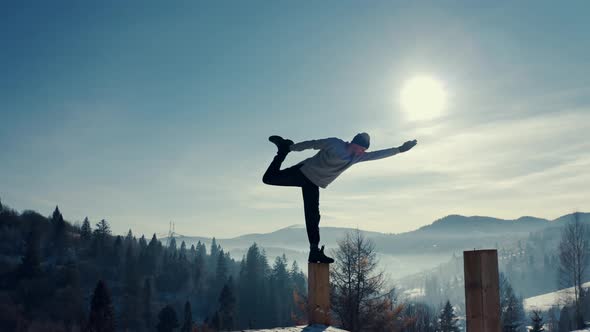 Traveler Practicing Yoga in the Winter Mountains and Enjoying Life