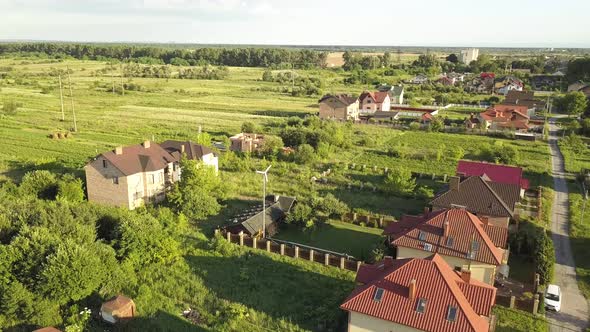 Aerial view of an autonomous house with solar panels on roof and wind generator turbine 