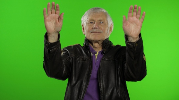 Elderly Caucasian Grandfather Rocker and Biker Man Waves His Hands, Greets