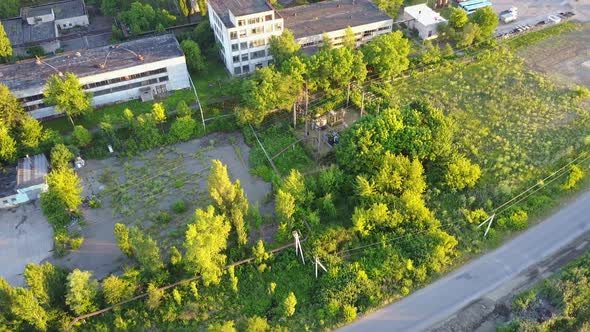 Old White Factory Buildings. Aerial shot of an old abandoned big factoty with a long smoke stack