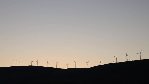 Wind Turbine Farm on a hill at Night in Slow Motion