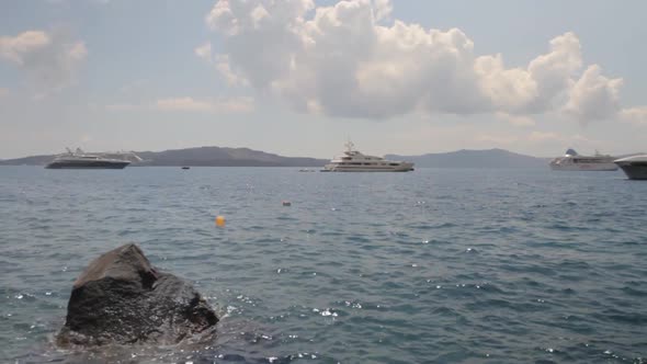 Yachts and cruises ships near the old sea port of Santorini.