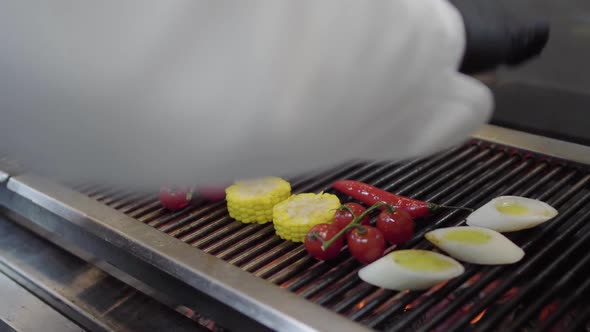 Hands of Chef Putting Vegetable on the Grill in the Restaurant Kitchen