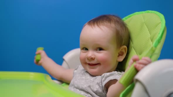 Funny Baby Eating Green Fresh Celery and Looking at Camera