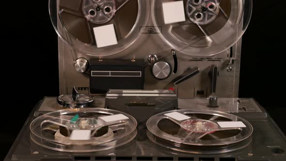 Two Reel to Reel tape recorders playing music together with four tapes