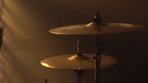 Hands Drummer Playing on Drum Kit on Stage in a Dark Studio with Smoke and Neon Lighting. Plates on