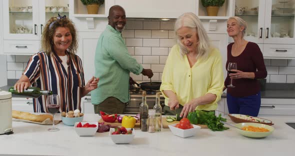 Animation of happy diverse female and male senior friends preparing meal in kitchen