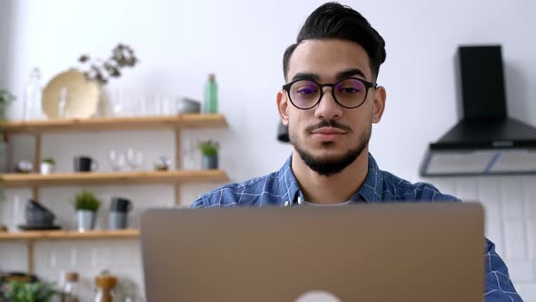 Closeup of an Attractive Positive Indian or Arabian Guy with Glasses Freelancer or Creative Designer