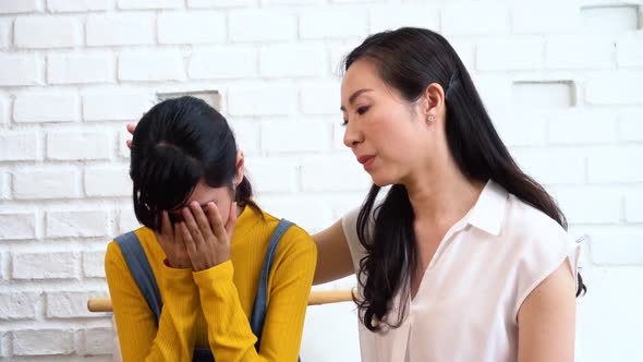 Asian Mother Comforting Crying Teenage Daughter in Miserable Stressed Depressed Sad State of Mind