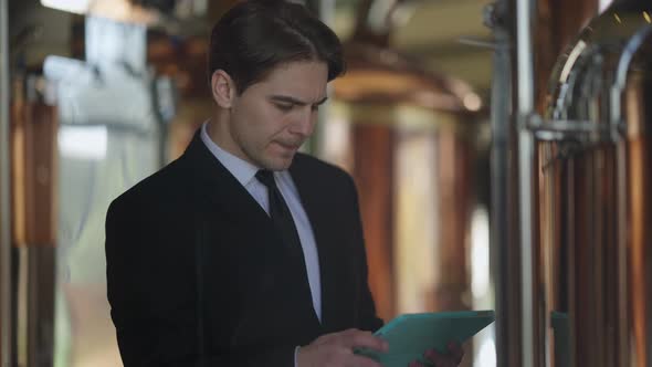 Portrait of Handsome Confident Beer Expert with Tablet Checking Brewing Process with Serious Facial