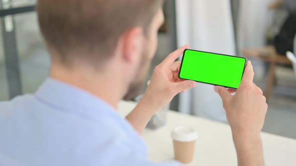 Young Creative Man Looking at Smartphone with Chroma Screen