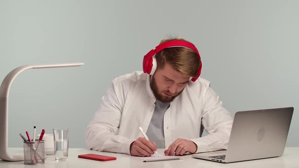 Student Tired of Watching Online Webinar Takes Off His Big Red Headphones and Relaxes