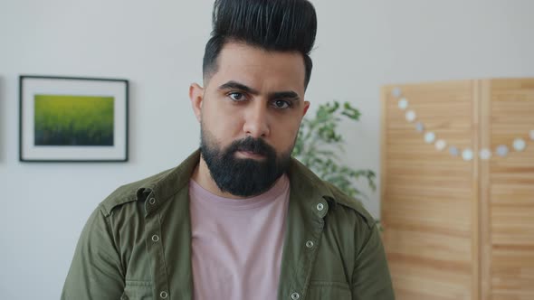 Portrait of Bearded Mixed Race Man Looking at Camera with Serious Face Standing at Home