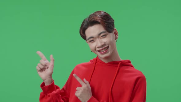 Inspired Asian Transgender Male Smile And Pointing To The Side While Standing In The Green Screen