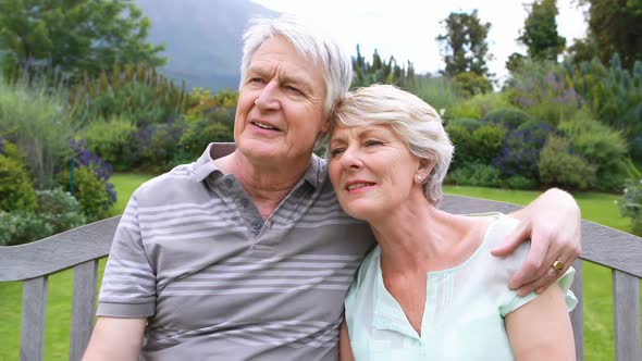 Senior couple talking and relaxing on bench