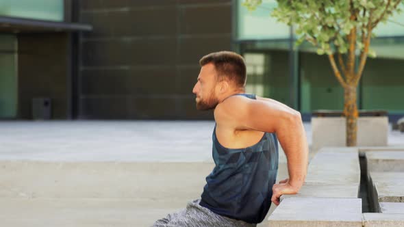 Young Man Doing Triceps Dip on City Street