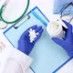 Doctor in white coat and blue latex gloves pours round white pills - VideoHive Item for Sale