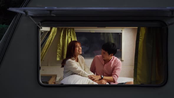 young couple in love tease each other in bed of a camper RV van motorhome