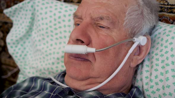 Old Sick Gray Haired Man Breathes Oxygen Through Tube For Health