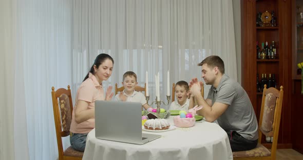 Parents with Two Teenage Boys Talking Video Call Using a Laptop Browsing Online TV Streams Enjoying