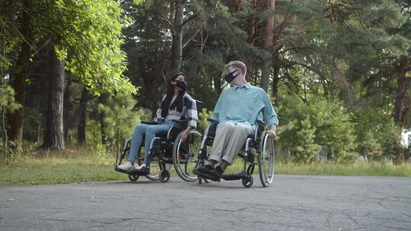 Two Disabled Young Friends are Walking in the Forest and Talking to Each Other Slow Motion
