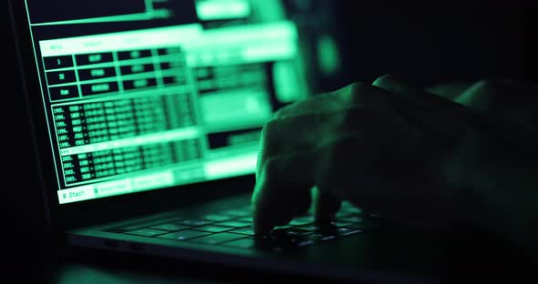 Hacker hands typing on a keyboard, close up view - Man coding using a noteboo