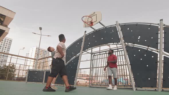 Father and Sons Playing Basketball Outdoors