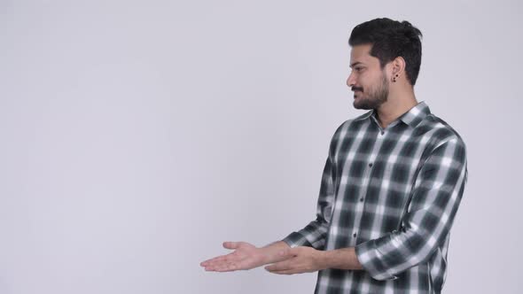 Portrait of Young Happy Bearded Indian Man Showing Something