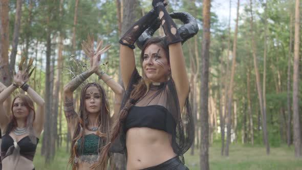 Skillful Young Women in Theatrical Costumes of Forest Nymphs Dancing in Forest Showing Perfomance or