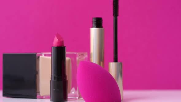 Decorative Cosmetics and Make Up Sponge on Pink Background