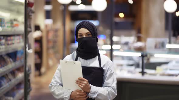 Portrait of Supermarket Female Muslim Worker Standing with Tablet in Hands