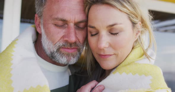 Happy caucasian mature couple wrapped in the blanket