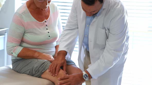 Physiotherapist giving knee therapy to senior woman