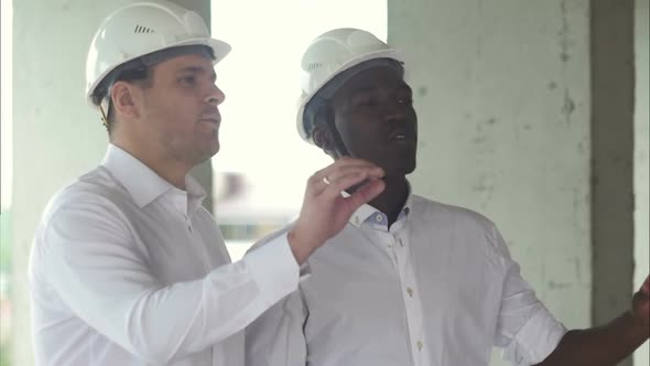 Two Businessman Looking Away for New Project While Working at Constructions Site in City Scape alt