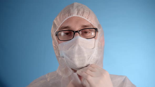 Man in Protective Jumpsuit Removes Medical Mask Hood Sighs Deeply