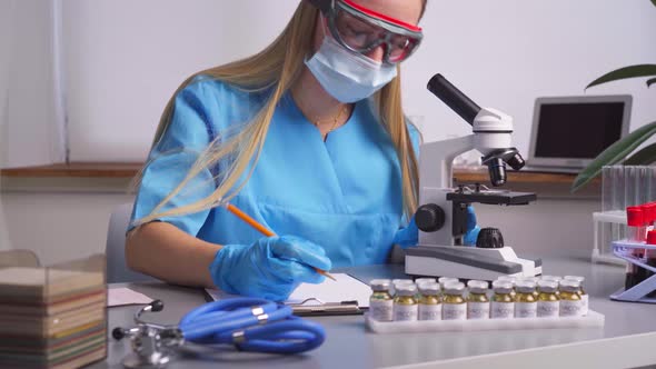 Woman Laboratory Worker Taking Notes About Blood Samples