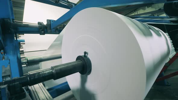 Factory Machine with a Massive Paper Roll Getting Wound