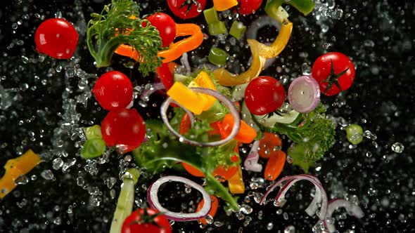 Super Slow Motion Shot of Flying Cuts of Colorful Vegetables and Water Drops at 1000Fps