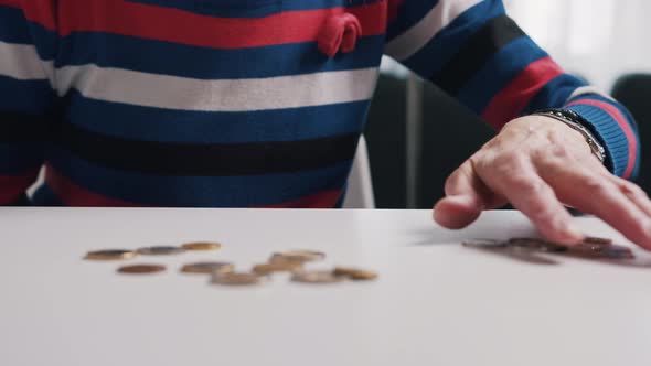 Poor Old Woman Counting Coins on the Table