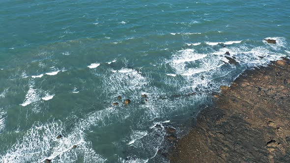 Stone beach and waves aerial shot