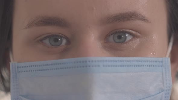 Extreme Close-up of Grey Eyes of Young Woman in Protective Mask. Beautiful Brunette Caucasian Girl