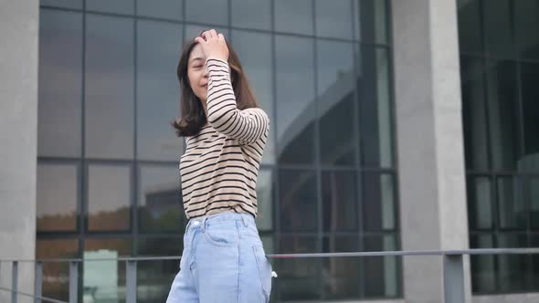 College girls stand in the wind in the glass building in front of the classroom.