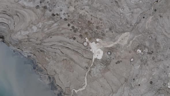 Extreme long shot, satellite view, dead sea shore, flood stream and sinkholes